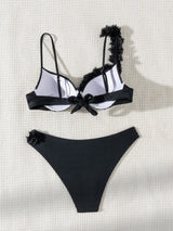 Black and white bikini set with floral details on a light background