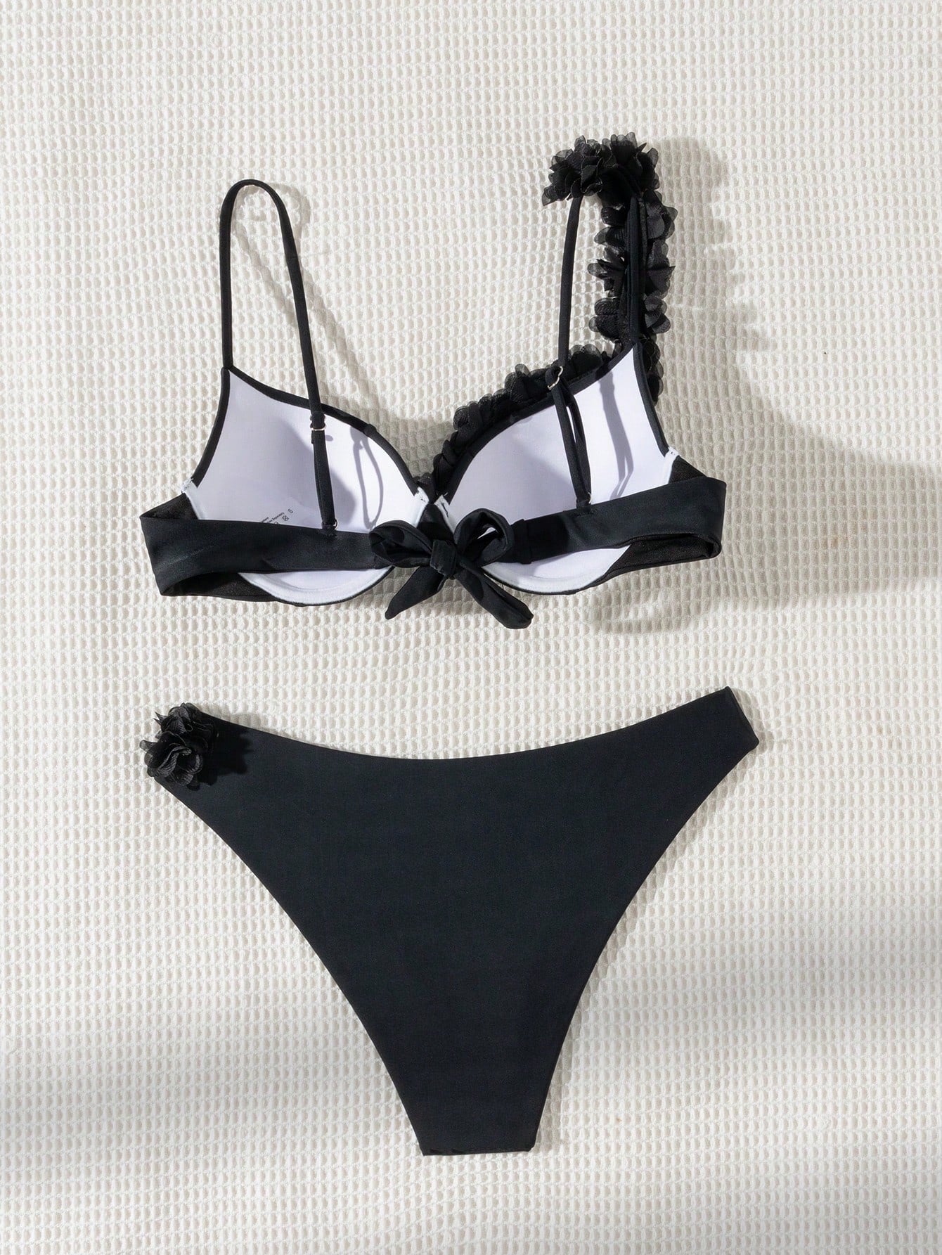 Black and white bikini set with floral details on a light background