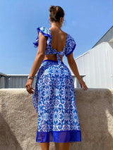 Woman wearing a blue and white patterned dress with a clear sky background