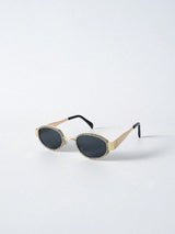 Sunglasses with gold frame and black lenses on a white background