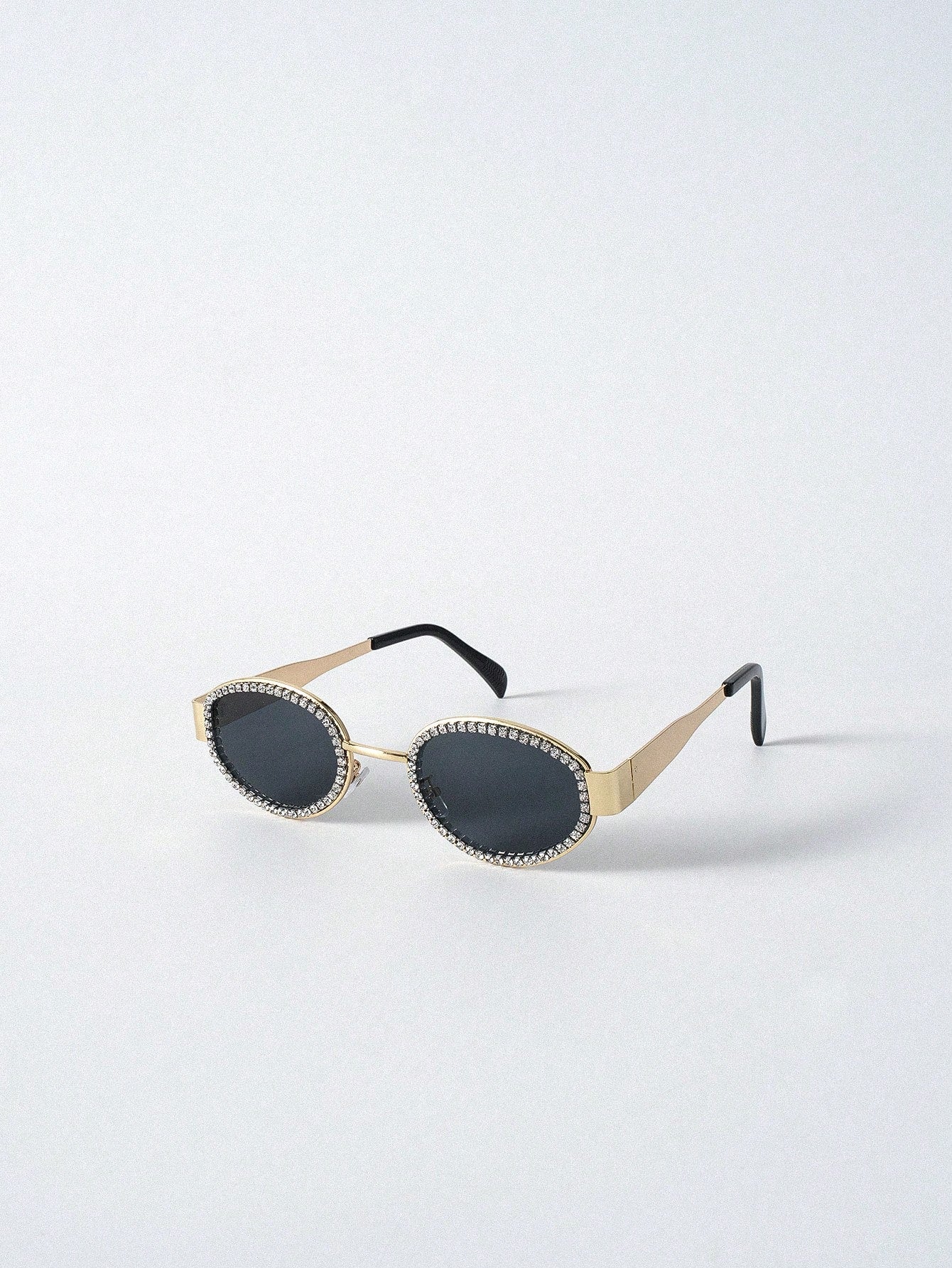 Sunglasses with gold frame and black lenses on a white background