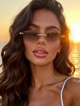 Woman wearing sunglasses with a sunset background