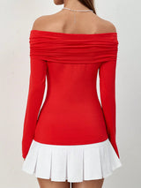 A woman wearing a bright red off-the-shoulder long-sleeve top with a pleated white mini skirt, shown from the back against a plain light background.
