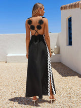 Woman wearing a black dress with floral back design on a rooftop.