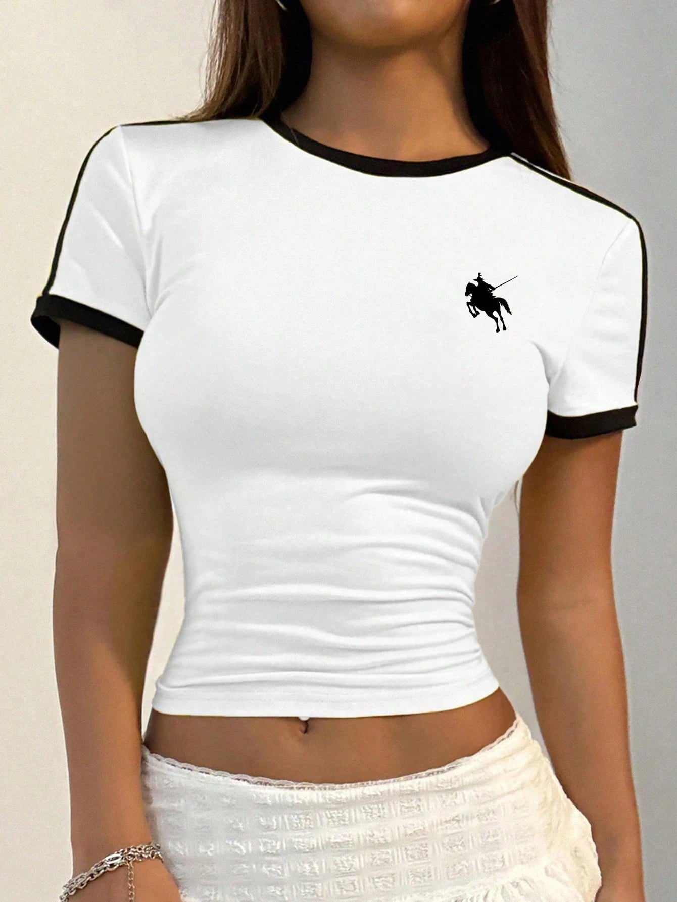 White t-shirt with black trim and logo worn by a person on a neutral background