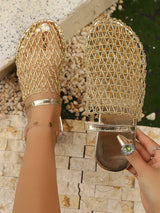 Gold mesh sandals being worn with a stone wall background