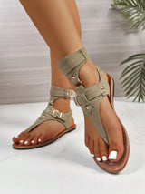 Beige sandals worn by a person on a white background