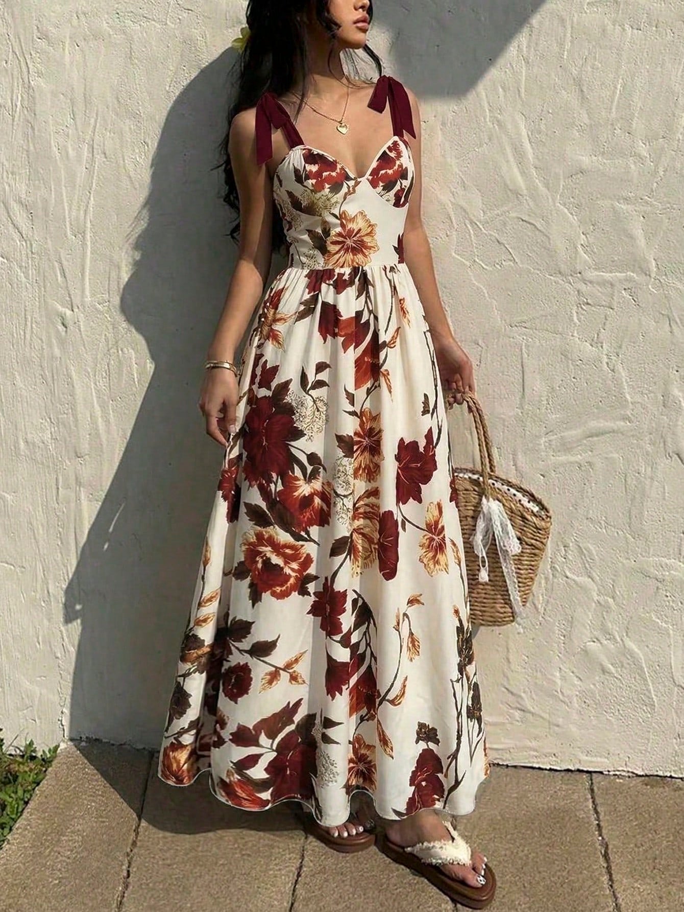 Woman wearing a floral dress against a white wall