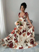 Woman wearing a floral dress holding flowers indoors.