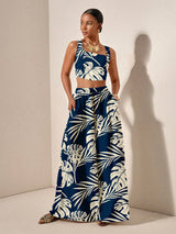 Woman wearing a blue and white leaf-patterned outfit against a beige background